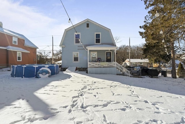 snow covered house featuring covered porch