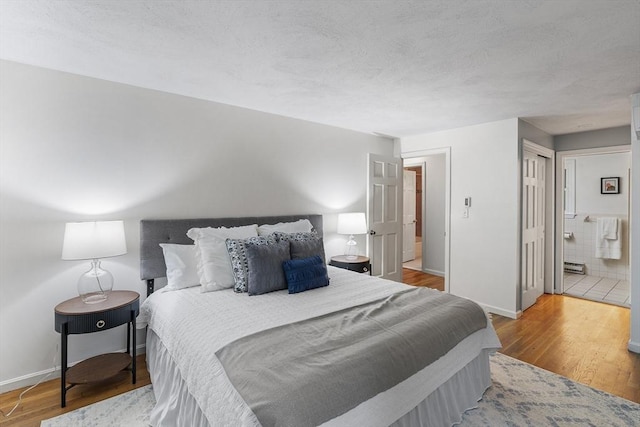 41 Harvey Ln, Westborough, MA 01581 - bedroom with wood finished floors, ensuite bathroom, and a textured ceiling