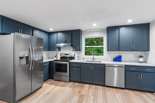41 Harvey Ln, Westborough, MA 01581 - kitchen featuring stainless steel appliances, under cabinet range hood, light countertops, blue cabinets, and tasteful backsplash