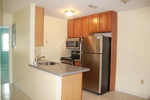 121 Tall Oaks Dr Unit F, Weymouth, MA 02190 - kitchen with appliances with stainless steel finishes, a peninsula, light countertops, and brown cabinets