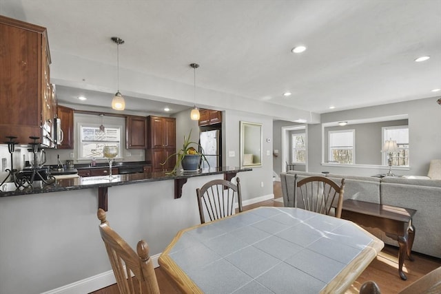 dining space featuring baseboards, wood finished floors, and recessed lighting