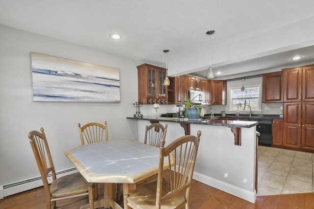 dining space with a baseboard heating unit, recessed lighting, and light wood-style flooring