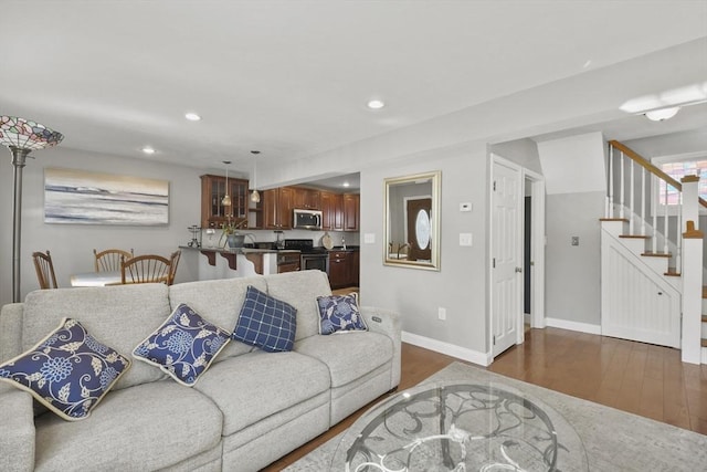 living room featuring dark wood-style floors, recessed lighting, stairway, and baseboards