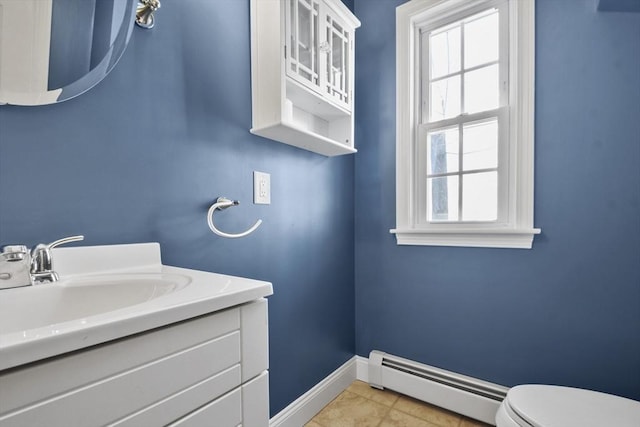 half bathroom featuring tile patterned flooring, toilet, vanity, baseboards, and baseboard heating