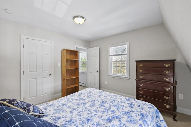 carpeted bedroom featuring a baseboard heating unit and baseboards