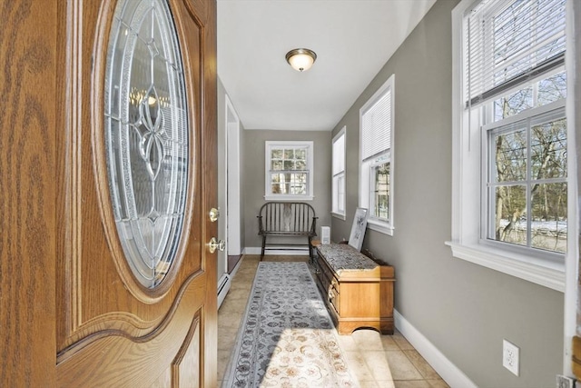 interior space featuring baseboard heating, light tile patterned flooring, and baseboards