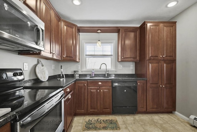 kitchen featuring dark countertops, a baseboard radiator, stainless steel appliances, a sink, and recessed lighting