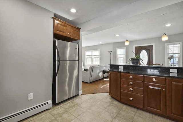 kitchen featuring a baseboard radiator, recessed lighting, hanging light fixtures, freestanding refrigerator, and dark stone countertops