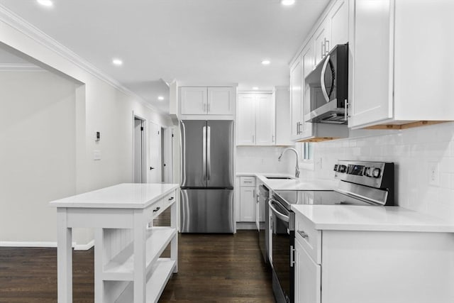 kitchen with dark wood-type flooring, sink, stainless steel appliances, decorative backsplash, and white cabinets