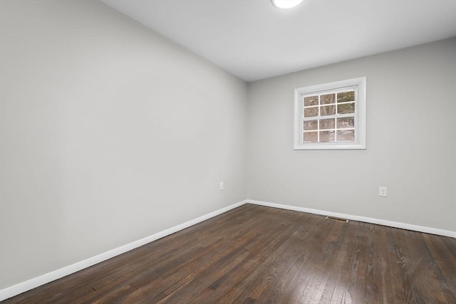 empty room with dark hardwood / wood-style flooring