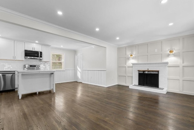 unfurnished living room with dark hardwood / wood-style floors, a fireplace, built in features, and crown molding