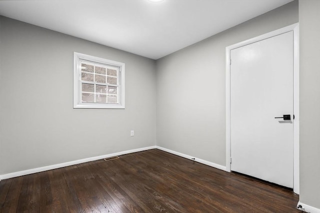 unfurnished room featuring dark wood-type flooring