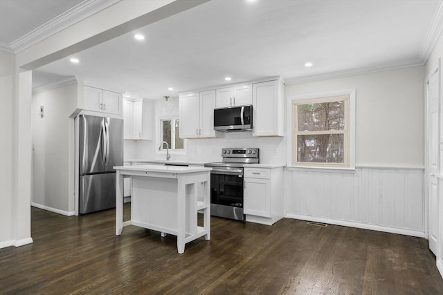 kitchen with white cabinetry, stainless steel appliances, dark hardwood / wood-style floors, and a kitchen island