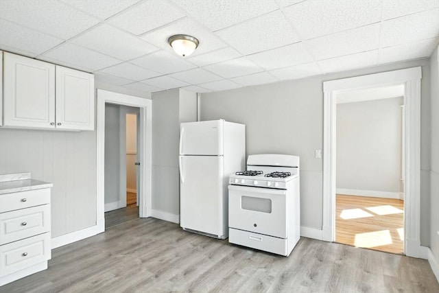 12-14 Kendall St, Springfield, MA 01104 - kitchen with white appliances, baseboards, white cabinetry, light wood finished floors, and a paneled ceiling