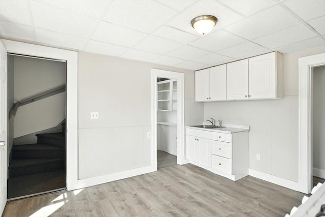 12-14 Kendall St, Springfield, MA 01104 - kitchen featuring a sink, a drop ceiling, light wood-type flooring, baseboards, and white cabinets