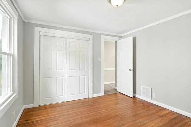 12-14 Kendall St, Springfield, MA 01104 - unfurnished bedroom featuring multiple windows, ornamental molding, wood finished floors, a closet, and baseboards