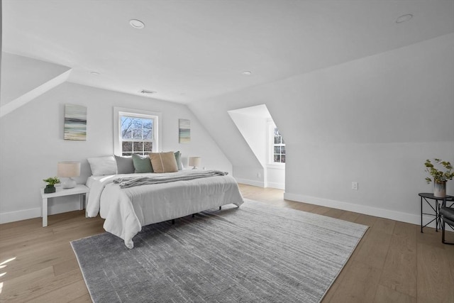 bedroom featuring visible vents, baseboards, and wood finished floors