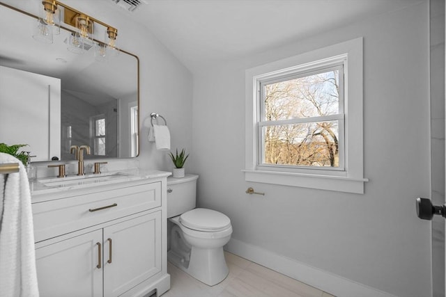 bathroom featuring visible vents, toilet, vanity, and baseboards