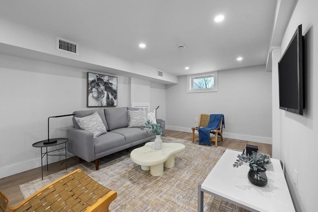 living area with recessed lighting, wood finished floors, and visible vents