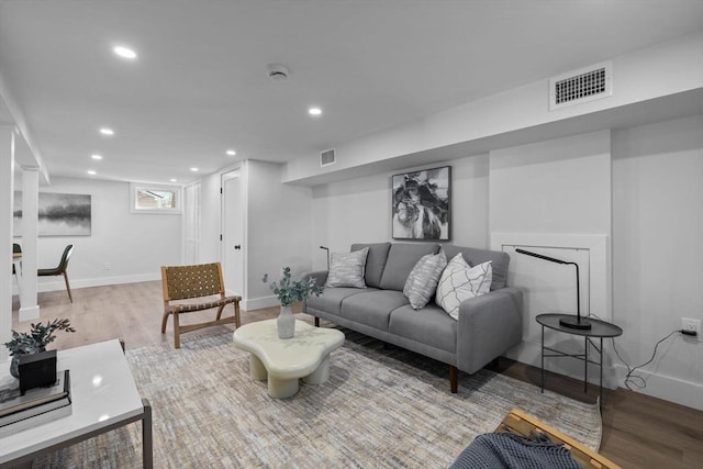 living room featuring recessed lighting, wood finished floors, visible vents, and baseboards