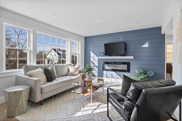 living room with a glass covered fireplace and wood finished floors