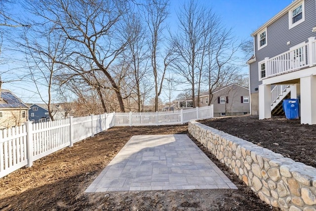 view of patio / terrace featuring stairs, a fenced backyard, and a residential view