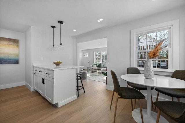 dining room with recessed lighting, light wood-style flooring, and baseboards