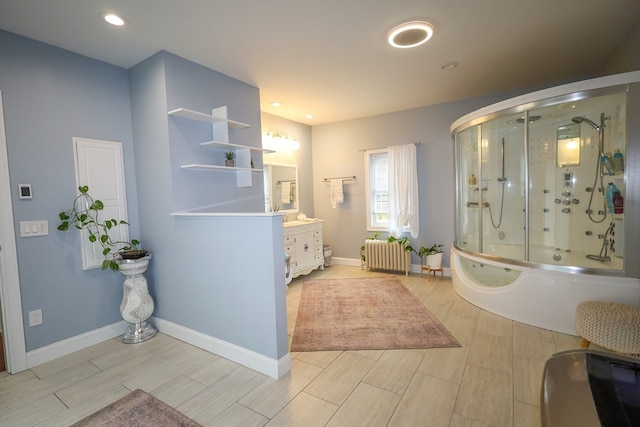 bathroom featuring vanity, separate shower and tub, and radiator