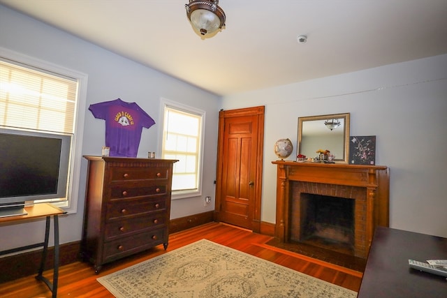 sitting room featuring a fireplace and dark wood-type flooring