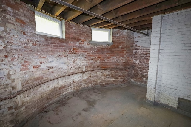 basement featuring brick wall