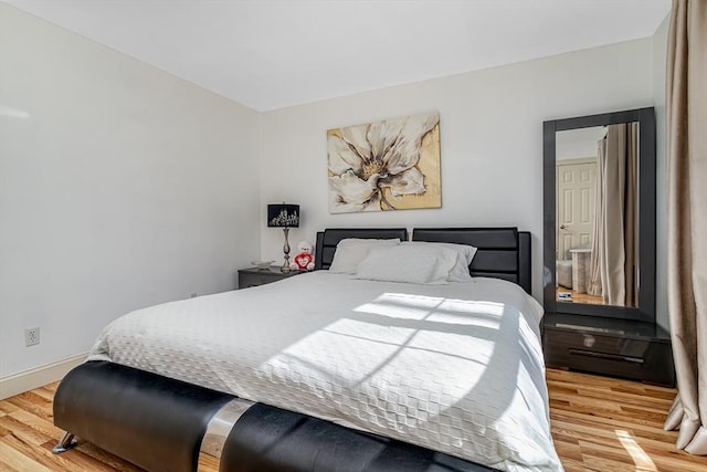 bedroom with baseboards and wood finished floors