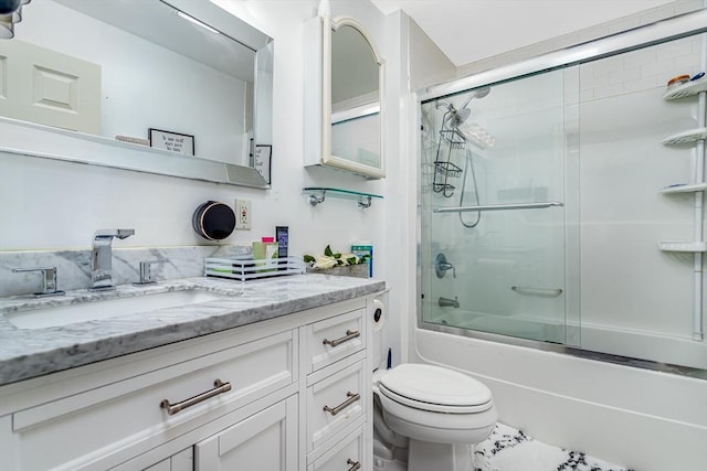 bathroom with combined bath / shower with glass door, toilet, and vanity