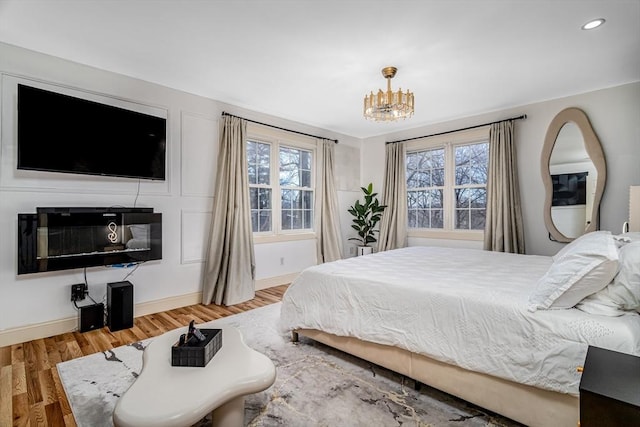 bedroom with a notable chandelier, recessed lighting, baseboards, and wood finished floors