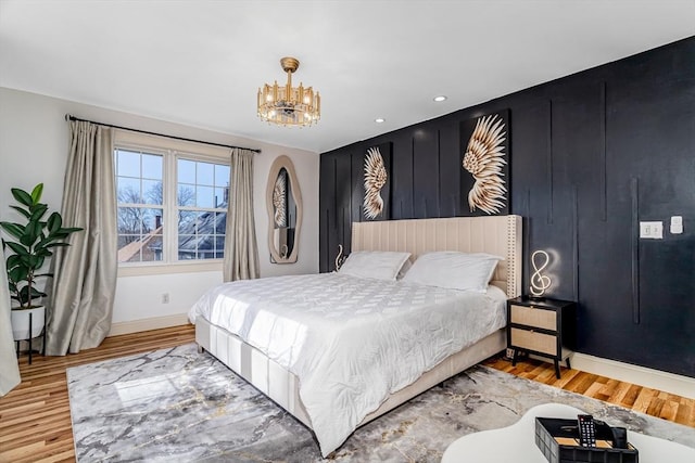 bedroom with recessed lighting, a notable chandelier, wood finished floors, and baseboards