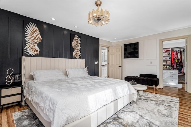 bedroom with a chandelier and wood finished floors