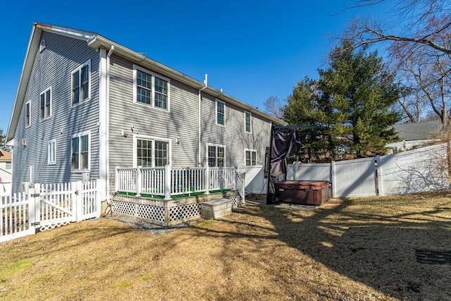 rear view of property with a deck, a gate, a fenced backyard, and a yard