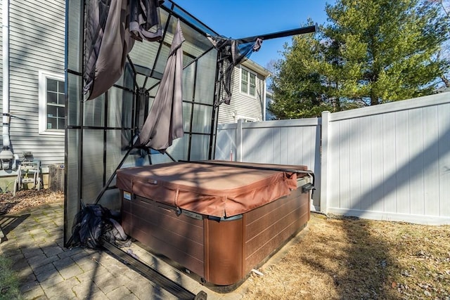 view of patio / terrace with fence and a hot tub