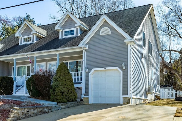 view of front of property featuring concrete driveway, a garage, covered porch, and a shingled roof