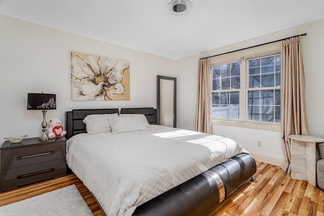 bedroom with light wood-style flooring and baseboards