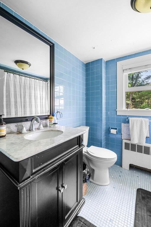 13 Clarks Rd, Amesbury, MA 01913 - bathroom with radiator, tile walls, tile patterned flooring, vanity, and toilet
