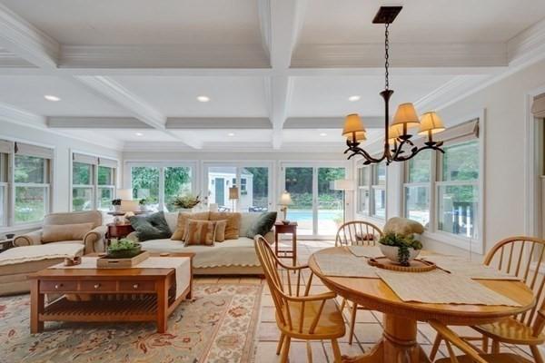 sunroom featuring plenty of natural light, coffered ceiling, beamed ceiling, and an inviting chandelier