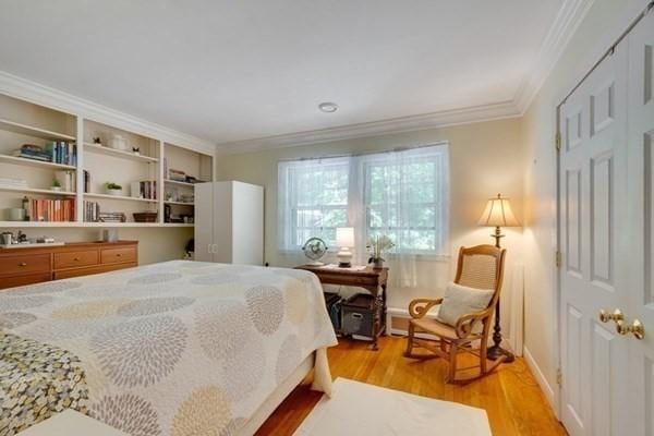 bedroom featuring light wood finished floors and crown molding