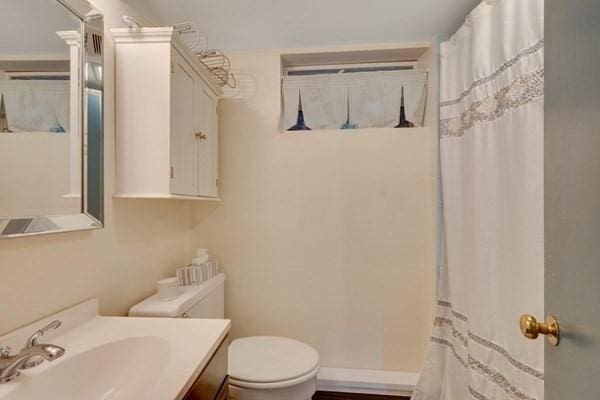 bathroom with toilet, a shower with curtain, and vanity