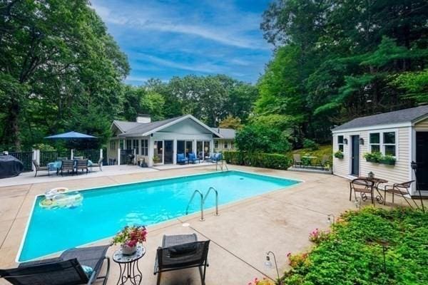 pool with a patio, an exterior structure, and an outdoor structure