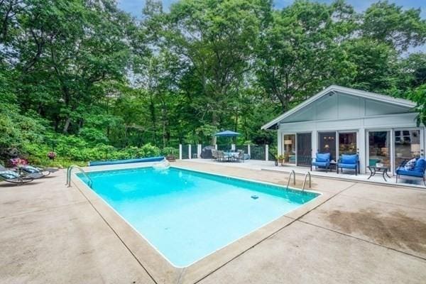 community pool featuring a storage structure, an outbuilding, and a patio