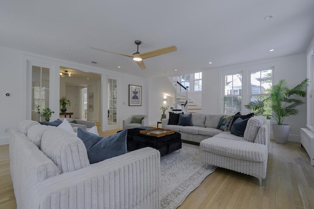 living room featuring ceiling fan and light hardwood / wood-style floors