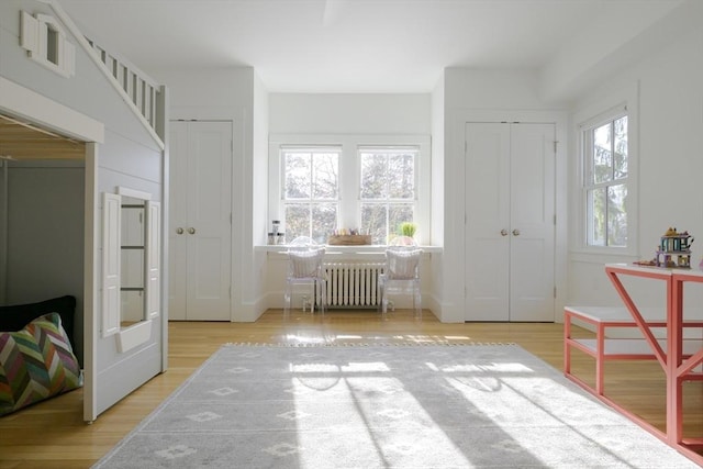 interior space featuring plenty of natural light, radiator, and light hardwood / wood-style floors