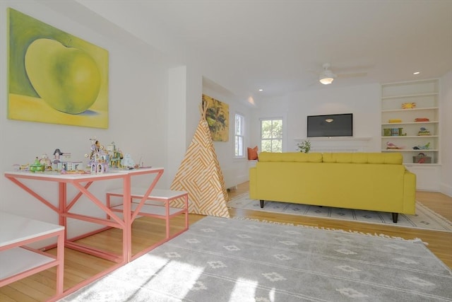 living room featuring built in shelves and light hardwood / wood-style floors