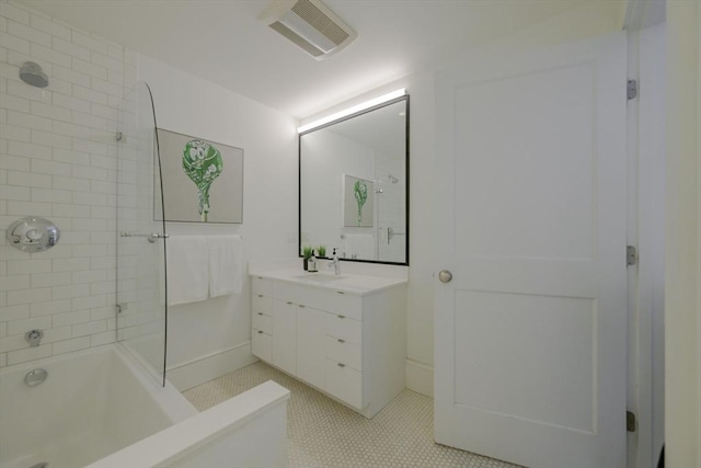 bathroom with tile patterned flooring, vanity, and tiled shower / bath