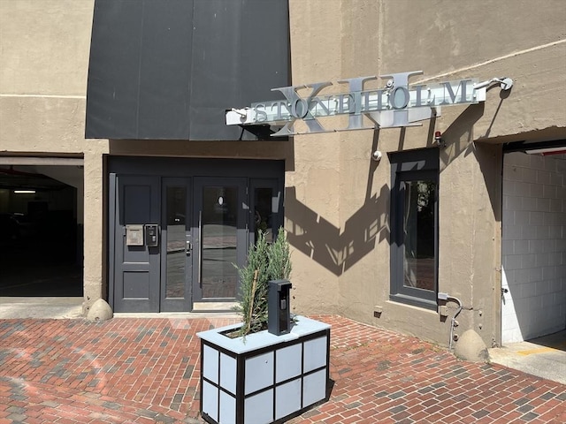 12 Stoneholm St Unit 313, Boston, MA 02115 - property entrance featuring french doors, stucco siding, and a pergola